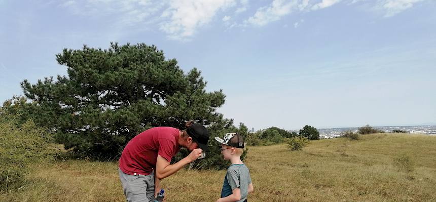 Naturpädagoge Tyler hilft den Kindern bei der Becherlupensuche. © FdPH/Girsch