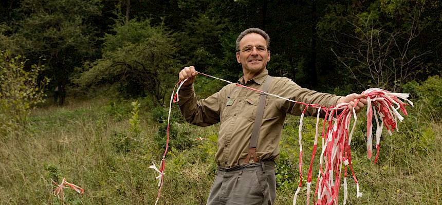 Biologe Alex markiert mit Absperrband, welche Büsche stehen bleiben sollen. © FdPH/J.F. Fischer